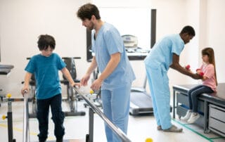 Kids during physical rehab each working with their physical therapist at the clinic