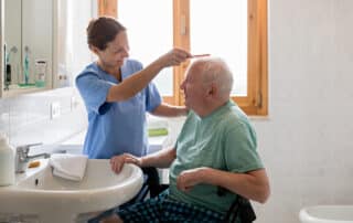 Home Caregiver with senior man in bathroom